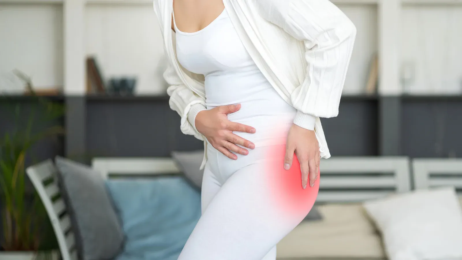 A woman standing with a hand pressed to her hip, the joint highlighted in red