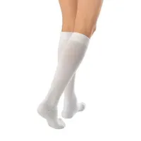 A pair of legs in white knee-high JOBST ActiveWear compression socks, seen from the side
