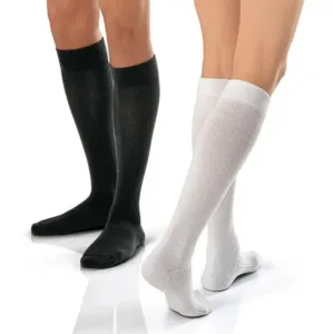 Knee-high compression socks in black and in white, each pair worn on the lower legs