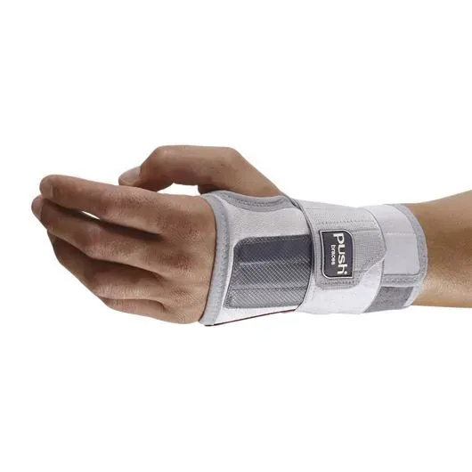 A grey and white Push wrist brace worn on the back of the hand, with a wide strap fastened across the wrist and the fingers and thumb left free