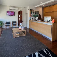 A clinic reception desk and waiting area with chairs along a street-facing window