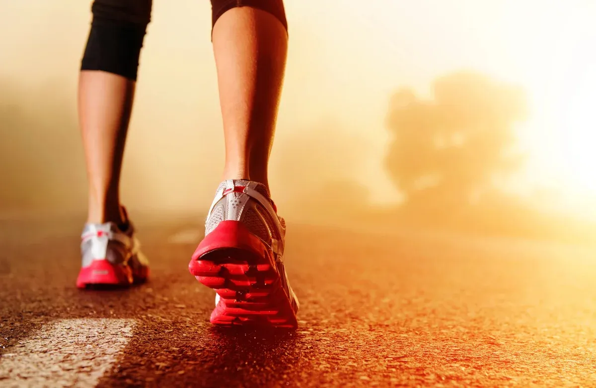 Runner's legs and shoes mid-stride, representing a physiotherapy running assessment